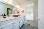 A spacious and airy Master bathroom provides ample counter space and double sinks with an adjacent shower.